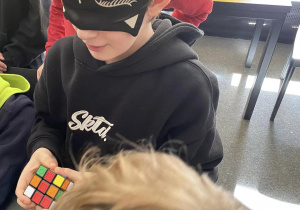 Uczeń układający kostkę Rubika