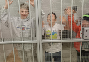 Uczniowie obecni na spotkaniu za kratami