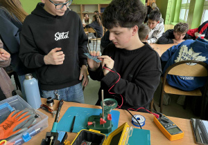 Uczniowie podczas lutowania układów na płytce