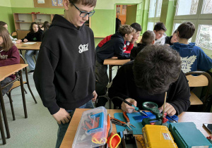 Uczniowie podczas lutowania układów na płytce